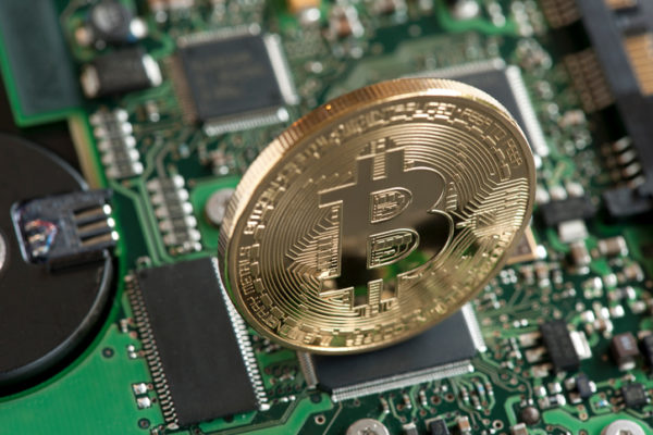 Bitcoin symbol, studio shot with circuit board background.