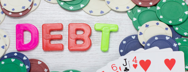 Illustration of poker coins and cards and the word debt written
